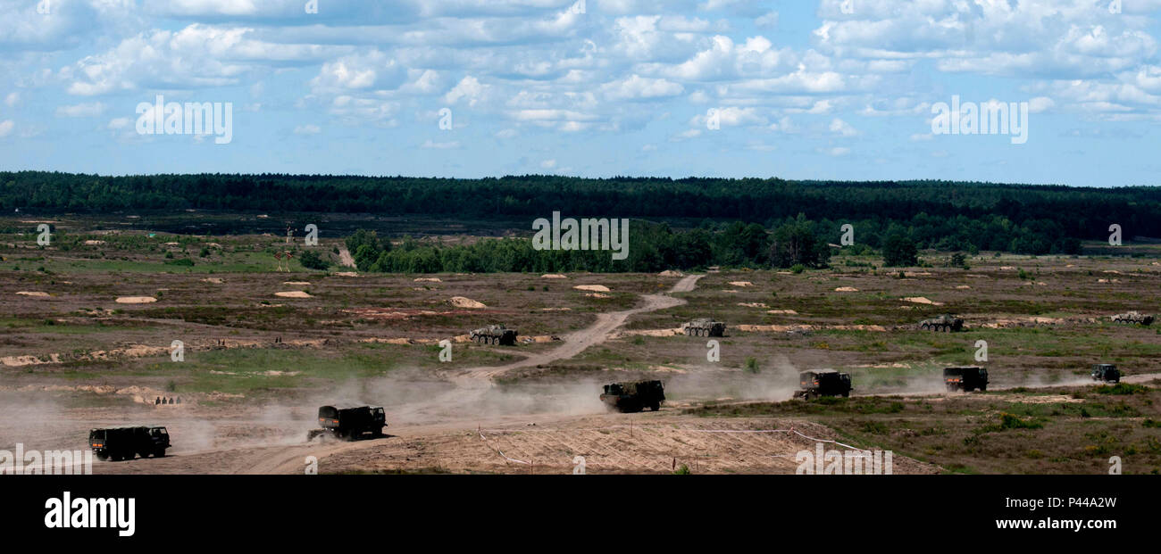 A military convoy travels through an open training area before being ...