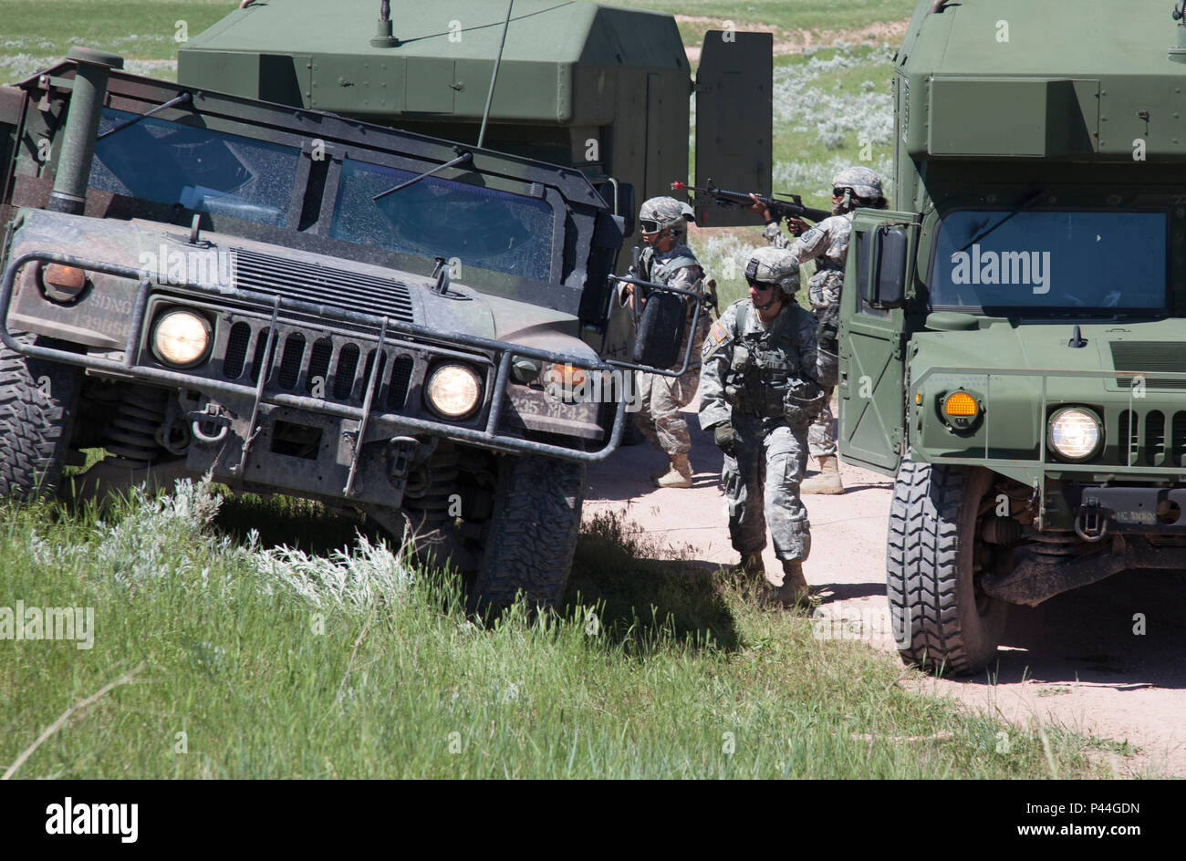 U.S. Army Soldiers of the 396th Medical Company (Ground Ambulance) and 235th Military Police Company, Army Reserve, react to a simulated ambush in a convoy operations exercise during the Golden Coyote exercise in Camp Guernsey, Wyo., June 15, 2016. The Golden Coyote exercise is a three-phase, scenario-driven exercise conducted in the Black Hills of South Dakota and Wyoming, which enables commanders to focus on mission essential task requirements, warrior tasks and battle drills. (U.S. Army photo by Spc. Chenyang Liu/Released) Stock Photo