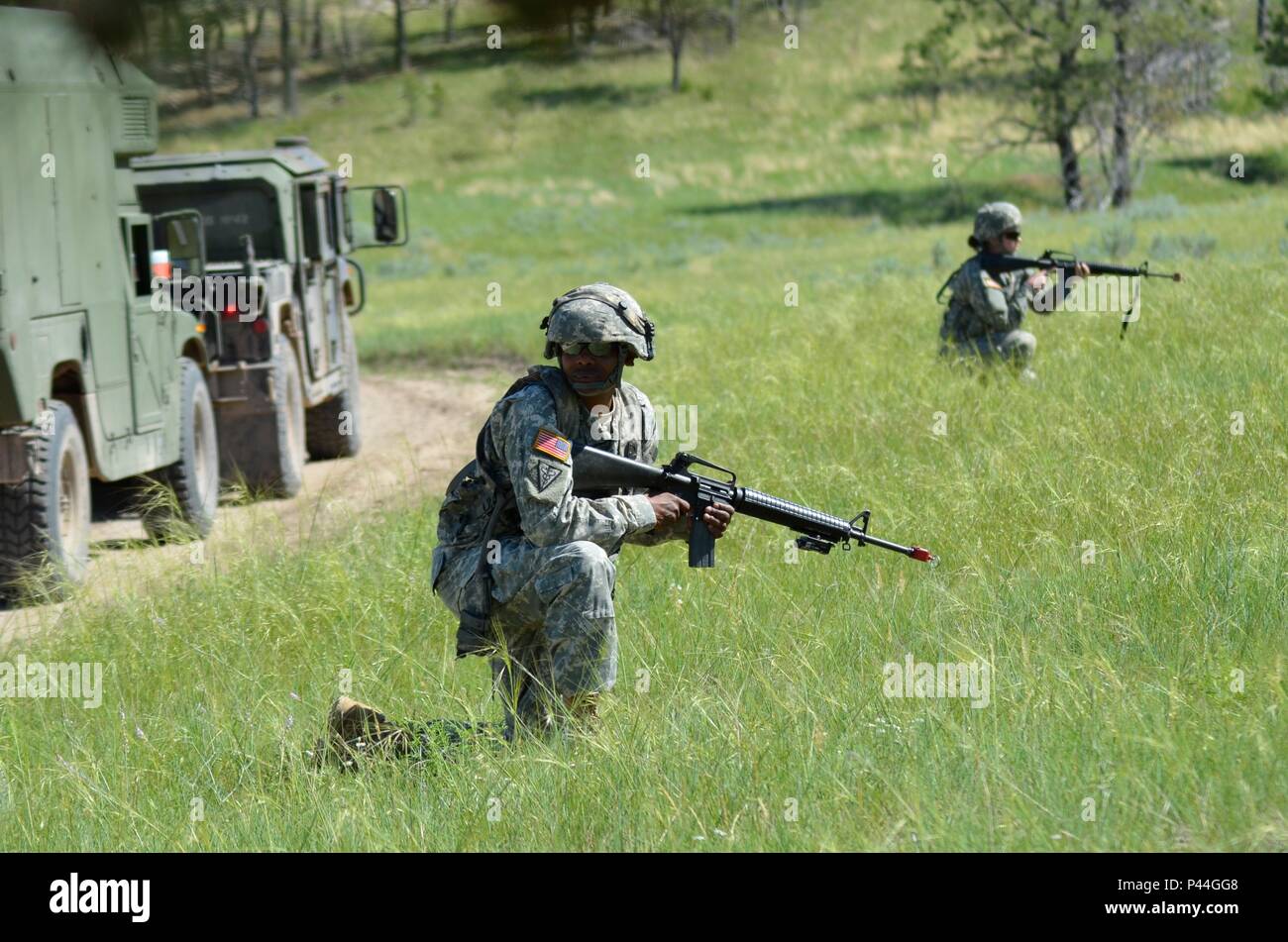 U.S. Army Staff Sgt. Kelvin Jones-Owes of the 396th Medical Company (Ground Ambulance), Army Reserve, provides security during a simulated convoy ambush in support of the Golden Coyote exercise in Camp Guernsey, Wyo., June 15th, 2016. The Golden Coyote exercise is a three-phase, scenario-driven exercise conducted in the Black Hills of South Dakota and Wyoming, which enables commanders to focus on mission essential task requirements, warrior tasks and battle drills. (U.S. Army photo by Pfc. Michael Britt/Released) Stock Photo