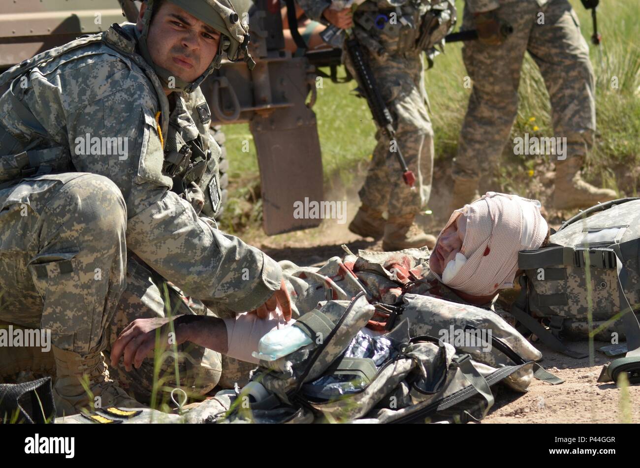 A U.S. Army Soldier of the 396th Medical Company (Ground Ambulance), Army Reserve tends to a casualty while awaiting a medical evacuation during a simulated convoy ambush in support of the Golden Coyote exercise in Camp Guernsey, Wyo., June 15th, 2016. The Golden Coyote exercise is a three-phase, scenario-driven exercise conducted in the Black Hills of South Dakota and Wyoming, which enables commanders to focus on mission essential task requirements, warrior tasks and battle drills. (U.S. Army photo by Pfc. Michael Britt/Not Released) Stock Photo