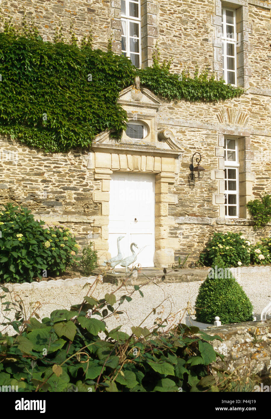Ornate stone pediment above doors of French country house in Normandy
