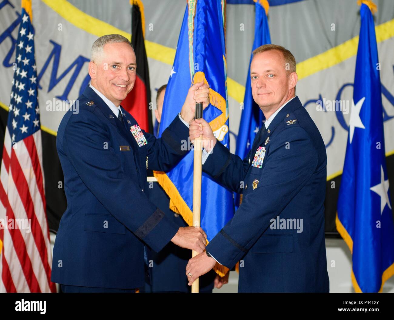 Maj. Gen. Frederick Martin, U.S. Air Force Expeditionary Center commander, passes the 521st Air Mobility Operations Wing flag to Col. Thomas Cooper during a change-of-command ceremony at Ramstein Air Base, Germany, June 14, 2016. With the passing of the flag, Cooper took command of more than 2,000 Airmen throughout Europe and Africa. (U.S. Air Force photo/Staff Sgt. Armando A. Schwier-Morales) Stock Photo