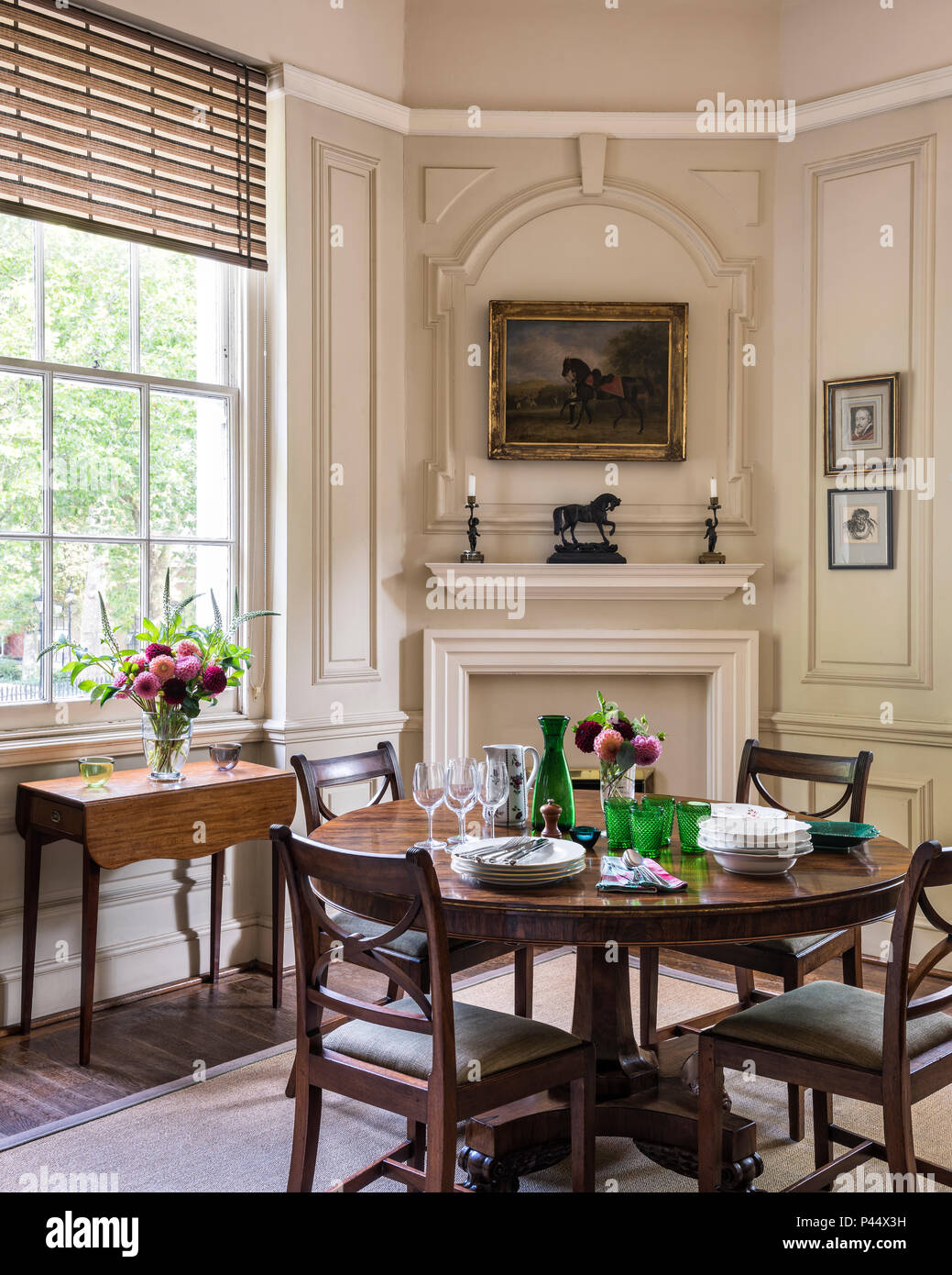 Wooden dining table and chairs in cream panelled room Stock Photo Alamy