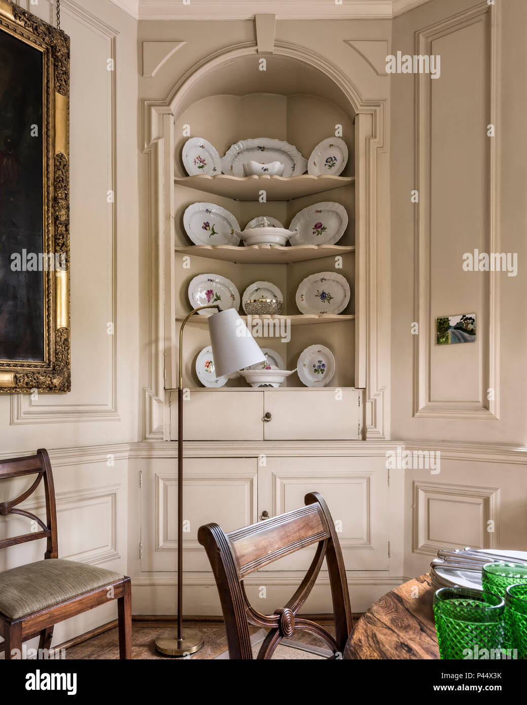 Decorative plates in recessed shelving with vintage lamp Stock Photo