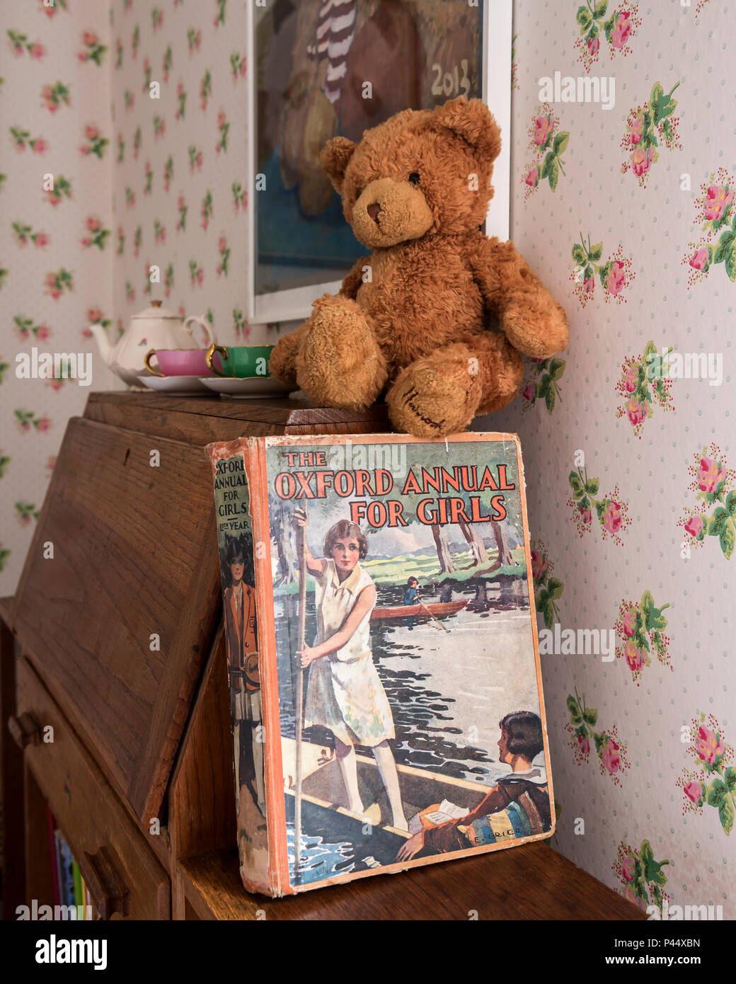 Teddybear and book on vintage desk in girls room Stock Photo