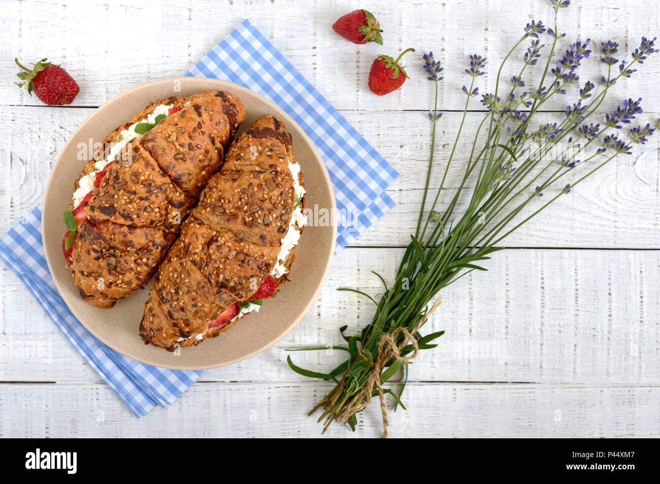 Cereal croissants with cream cheese and fresh strawberries. Useful breakfast. Proper nutrition