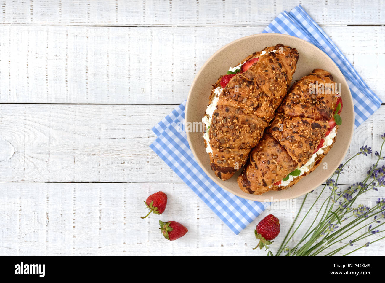 Cereal croissants with cream cheese and fresh strawberries. Useful breakfast. Proper nutrition