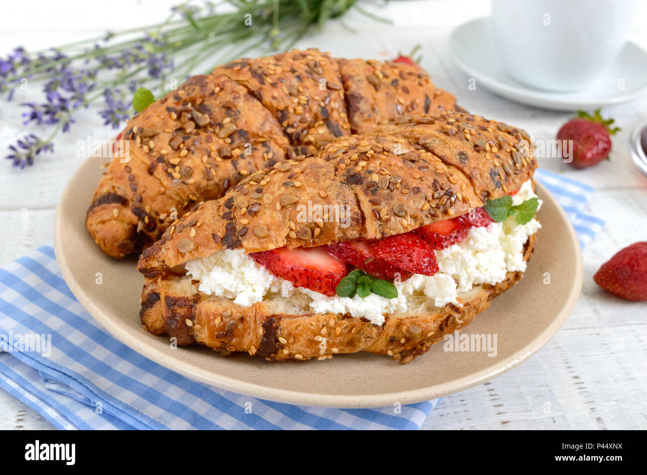 Cereal croissants with cream cheese and fresh strawberries. Useful breakfast. Proper nutrition