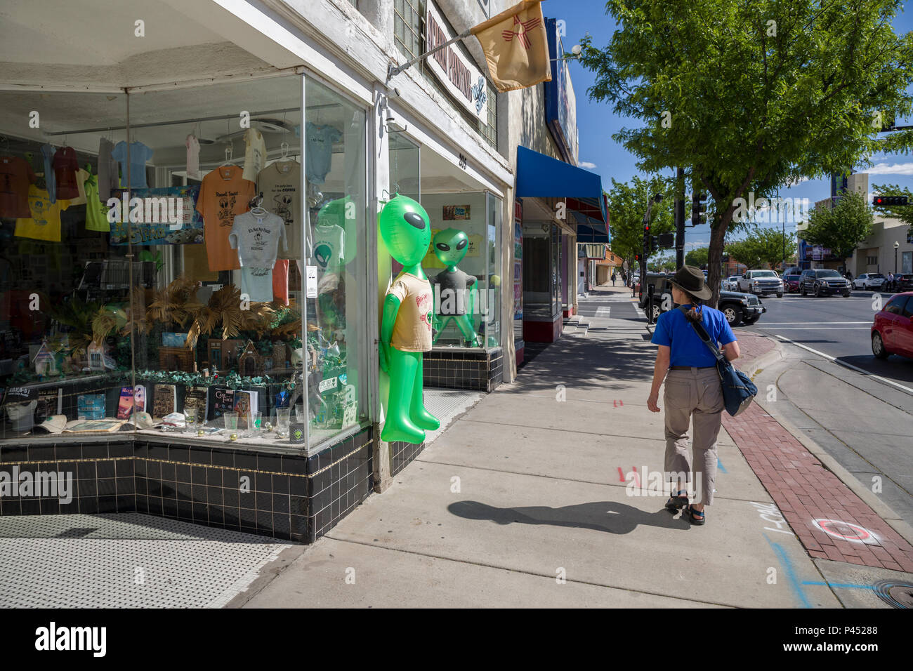 Woman walking past alien model in street, Roswell, New Mexico, USA Stock Photo