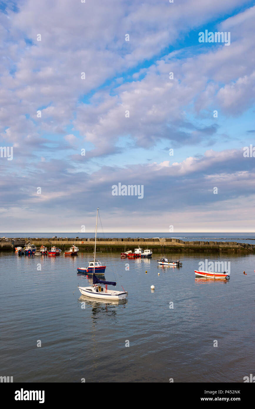 Small boats in the harbour at Staithes, North Yorkshire, North East England. A peaceful evening in May in this well known coastal village. Stock Photo