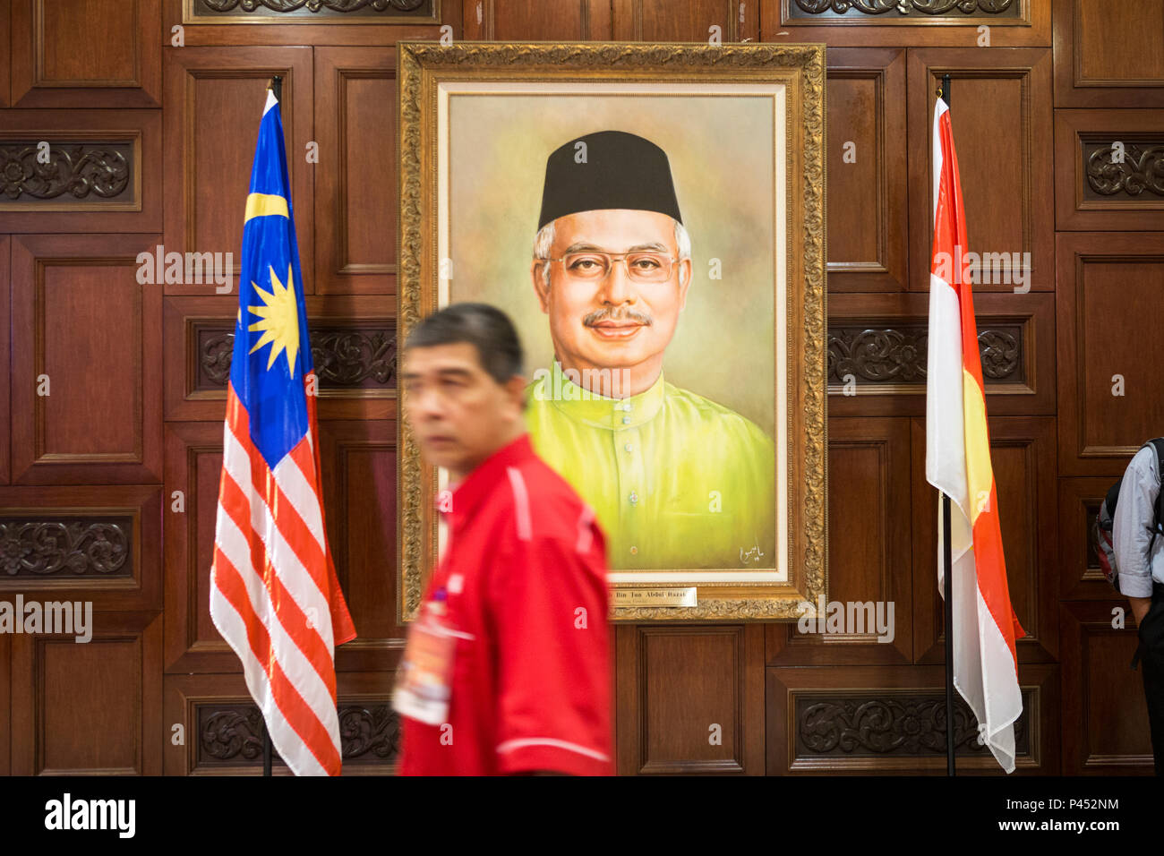 Man walks past a portrait of  Najib Razak, Malaysia's former Prime Minister, at the United Malays National Organisation (UMNO) headquarters at the Putra World Trade Center (PWTC) in Kuala Lumpur, Malaysia, on Tuesday, Dec. 8, 2015. Stock Photo