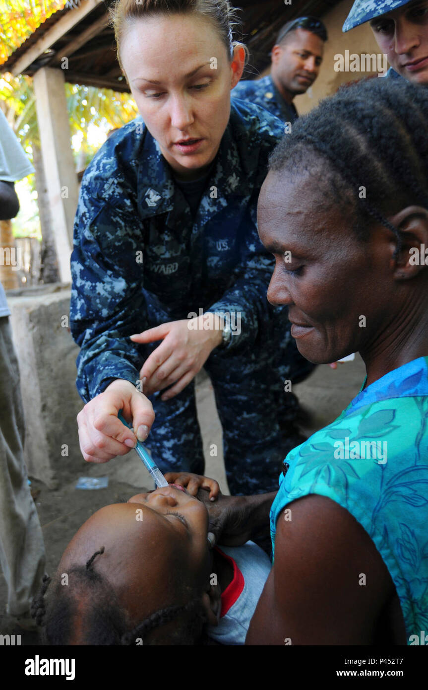 CERCA-LA-SOURCE, Haiti (Jan. 25, 2010) Hospital Corpsman 2nd Class Alexandra Howard, assigned to the guided-missile cruiser USS Bunker Hill (CG 52), gives medication to a Haitian child as part of continuing relief efforts in Haiti. Bunker Hill, along with the aircraft carrier USS Carl Vinson (CVN 70), is providing relief efforts as part of Operation Unified Response, a multi-national humanitarian and disaster relief operation following a 7.0 magnitude earthquake in Haiti on Jan. 12, 2010. Stock Photo