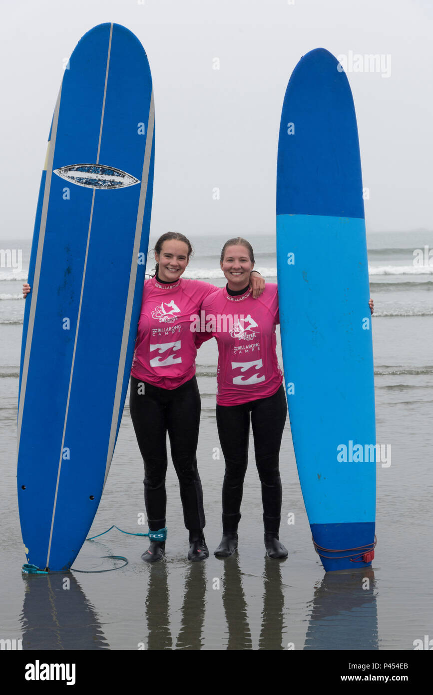 Female friends standing on the beach with surfboards, Cox Bay Beach