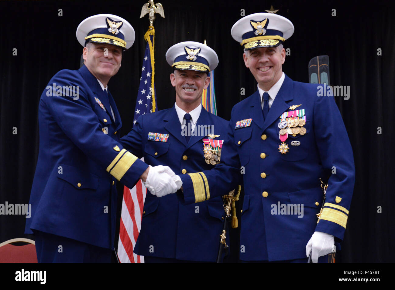During a formal U.S. Coast Guard change of command ceremony at the Elizabeth Peratrovich Conference Hall in Juneau, Alaska, command of the 17th District is transferred with senior officers standing together after During a formal U.S. Coast Guard change of command ceremony at the Elizabeth Peratrovich Conference Hall in Juneau, Alaska, command of the 17th District is transferred with senior officers standing together after