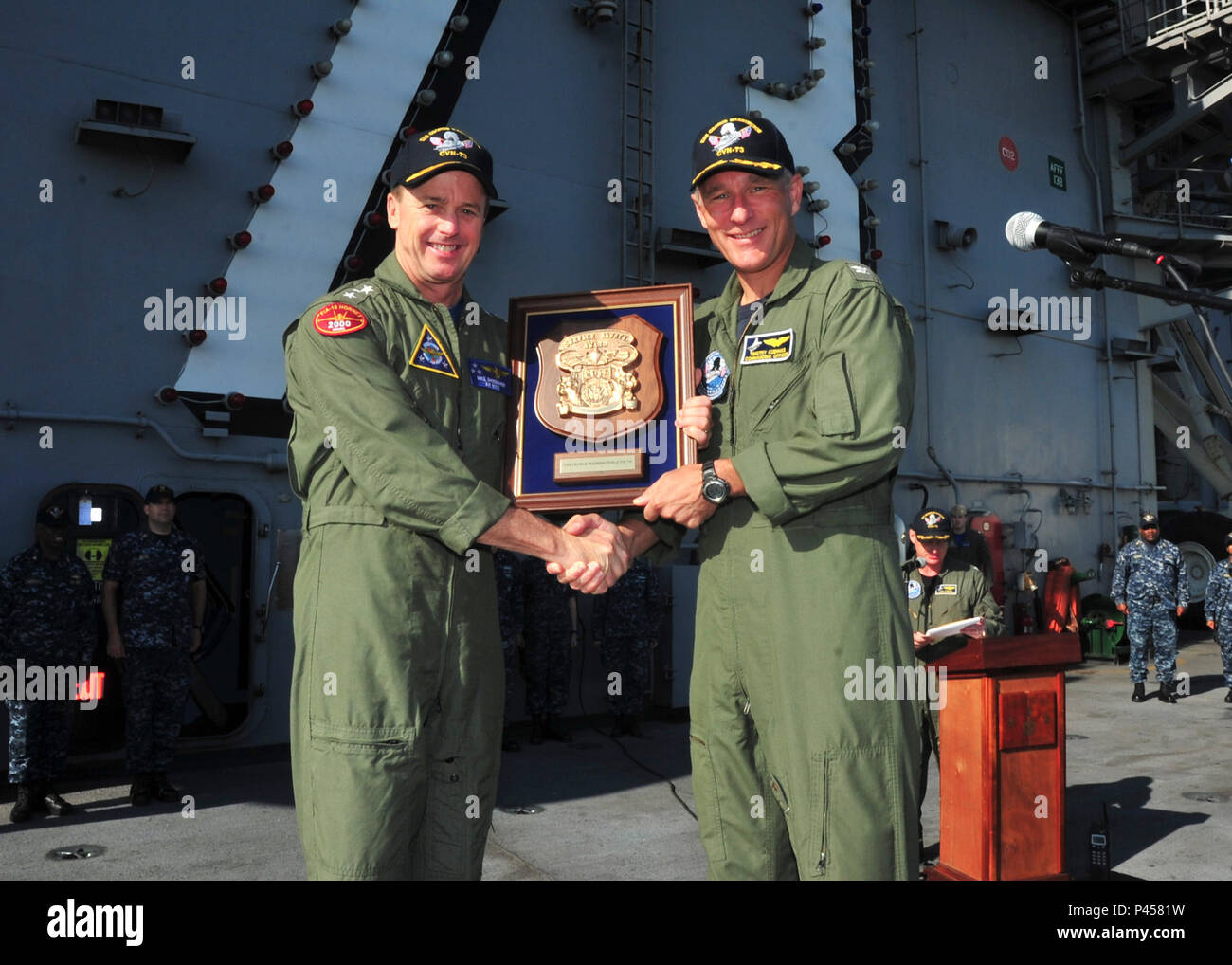 20160614-N-TR801-050 NORFOLK (June 14, 2016) Vice Adm. Michael Shoemaker, left, commander, Naval Air Forces, presents a 2015 Admiral Flatley Memorial Award plaque to Capt. Timothy C. Kuehhas, commanding officer of the aircraft carrier USS George Washington (CVN 73) during an all hands call on the flight deck.  The Admiral Flatley Memorial Award is based on the overall aviation safety record of the ship and air wing, as well as a type commander assessment of the ship’s safety program.  (U.S. Navy photo by Mass Communication Specialist Seaman Michael E. Wiese/Released) Stock Photo