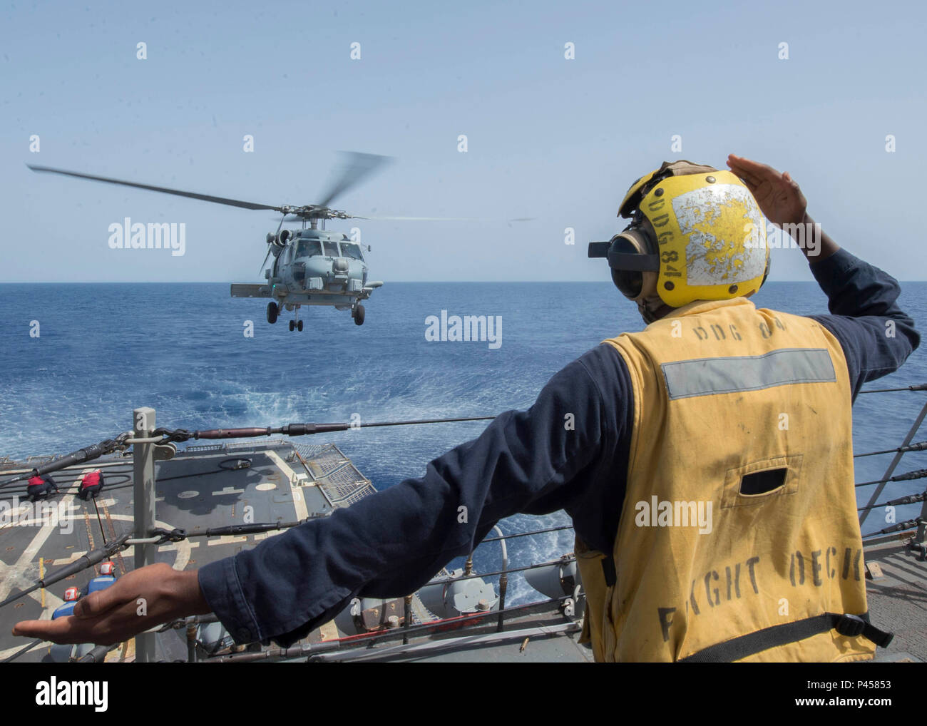 160612-N-AO823-088 RED SEA (June 12, 2016) Boatswain's Mate Seaman Jabri Singleton signals an MH-60R Sea Hawk helicopter, assigned to the 'Proud Warriors' of Helicopter Maritime Strike Squadron (HSM) 72, during a helicopter in-flight refueling exercise aboard guided-missile destroyer USS Bulkeley (DDG 84). Bulkeley is deployed as part of the Harry S. Truman Carrier Strike Group in support of Operation Inherent Resolve, maritime security operations, and theater security cooperation efforts in the U.S. 5th Fleet area of operations. (U.S. Navy photo by Mass Communication Specialist 2nd Class Mich Stock Photo