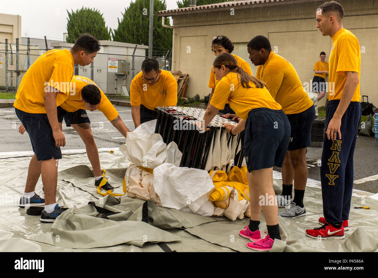 U.S. Navy Sailors from the Robert M. Casey Medical and Dental Clinic set up a three-line articulating frame shelter during first-receiver operations training at Marine Corps Air Station Iwakuni, Japan, June 9, 2016. Provided by the Decontamination, Education and Consulting on Nuclear, Biological and Chemical Limited Liability Company, the course educates first receivers in conducting decontamination, field treatment and saving victims from chemical, biological, radiological and nuclear threats. (U.S. Marine Corps photo by Lance Cpl. Aaron Henson/Released) Stock Photo