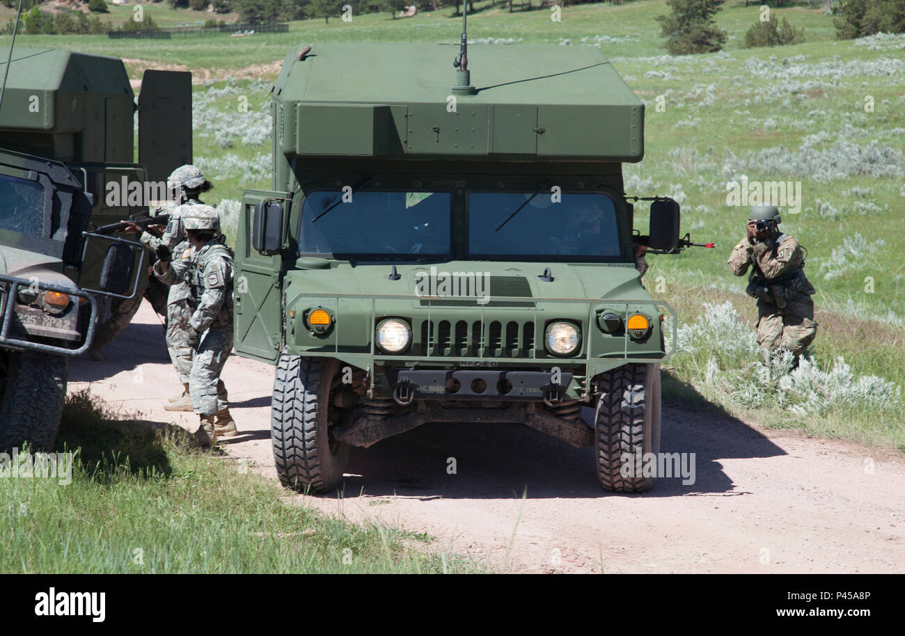U.S. Army Spc. Michael Britt of the 982nd Combat Camera Company (Airborne), Army Reserve, documents Soldiers of  396th Medical Company (Ground Ambulance) and 235th Military Police Company as they react to a simulated ambush in a convoy operations exercise during the Golden Coyote exercise in Camp Guernsey, Wyo., June 15, 2016. The Golden Coyote exercise is a three-phase, scenario-driven exercise conducted in the Black Hills of South Dakota and Wyoming, which enables commanders to focus on mission essential task requirements, warrior tasks and battle drills. (U.S. Army photo by Spc. Chenyang Li Stock Photo