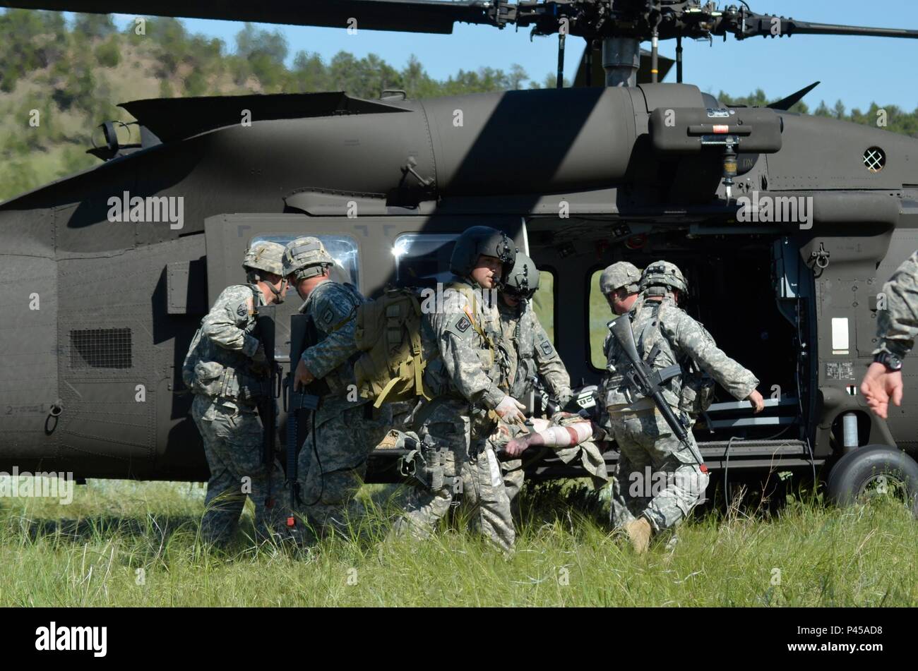 U.S. Army Soldiers of the 396th Medical Company (Ground Ambulance), Army Reserve and 235th Military Police Company, South Dakota Army National Guard, load casualties on a UH-60 Blackhawk during a simulated in support of the Golden Coyote exercise in Camp Guernsey, Wyo., June 15th, 2016. The Golden Coyote exercise is a three-phase, scenario-driven exercise conducted in the Black Hills of South Dakota and Wyoming, which enables commanders to focus on mission essential task requirements, warrior tasks and battle drills. (U.S. Army photo by Pfc. Michael Britt/Not Released) Stock Photo