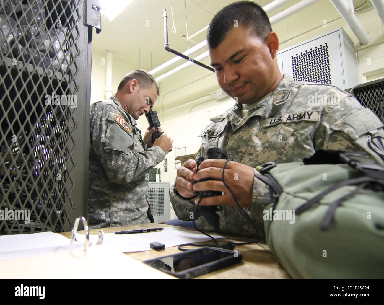 Arizona Army National Guard Spc. Thomas M. Ferguson and Sgt. Armono A. Aguilera, computer/detection systems repairers with the 3666th Support Maintenance Company, inspect PVS-14 night vision monoculars, June 22, at Fort Greely, Alaska, which is located approximately 100 miles southeast of Fairbanks, Alaska. The Arizona Guardsmen were part of a mobile repair team that inspected weapons and night vision optics for the Alaska National Guard’s 49th Missile Defense Battalion. (Arizona Army National Guard photo by Staff Sgt. Brian A. Barbour) Stock Photo