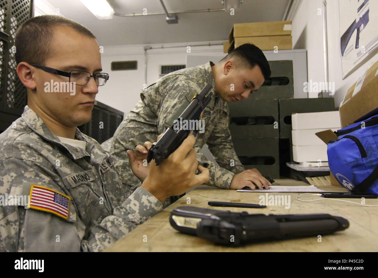 Arizona Army National Guard Spc. Sean M. Marciano and Sgt. Michael Restrepo, small-arms repairers with the 3666th Support Maintenance Company, inspect M9 pistols, June 22, at Fort Greely, Alaska, which is located approximately 100 miles southeast of Fairbanks, Alaska. The two Arizona Guardsmen were at Fort Greely during their annual training as part of mobile repair team that inspected nearly 600 weapons for the Alaska National Guard’s 49th Missile Defense Battalion. (Arizona Army National Guard photo by Staff Sgt. Brian A. Barbour) Stock Photo