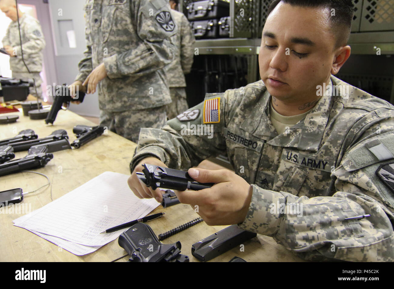 Arizona Army National Guard Sgt. Michael Restrepo, a small-arms repairer with the 3666th Support Maintenance Company, dismantles a M9 pistol during an inspection, June 22, at Fort Greely, Alaska, which is located approximately 100 miles southeast of Fairbanks, Alaska. Restrepo was part mobile repair team from Arizona that inspected nearly 600 weapons during their annual training for the Alaska National Guard’s 49th Missile Defense Battalion. (Arizona Army National Guard photo by Staff Sgt. Brian A. Barbour) Stock Photo