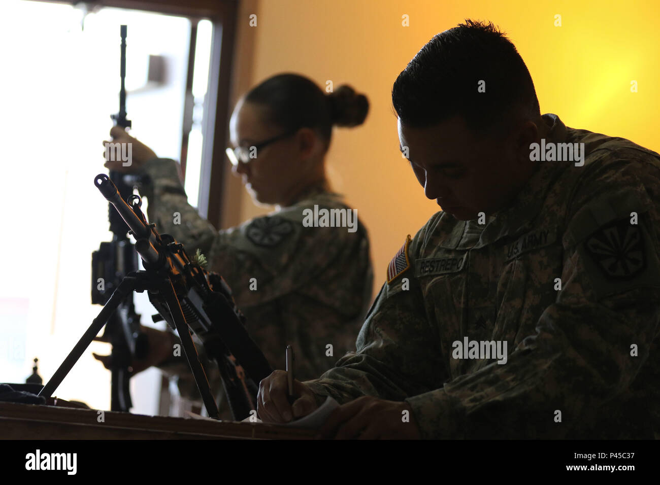 Arizona Army National Guard Sgt. Rachel H. Mick and Sgt. Michael Restrepo, small-arms repairers with the 3666th Support Maintenance Company, conduct weapons inspections on a M4 carbine and M240 machine gun, June 22, at Fort Greely, Alaska, which is located approximately 100 miles southeast of Fairbanks, Alaska. The two Arizona Guardsmen were part mobile repair team that inspected nearly 600 weapons during their annual training for the Alaska National Guard’s 49th Missile Defense Battalion. (Arizona Army National Guard photo by Staff Sgt. Brian A. Barbour) Stock Photo