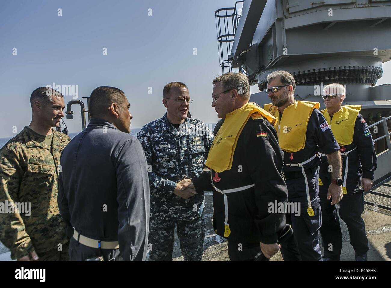 BALTIC SEA (June 04, 2018) Capt. Brian J. Finman, center, deputy commodore of Amphibious Squadron 4, U.S. Marine Corps Maj. Joseph P. Murphy, far left, commander of landing forces for the 26th Marine Expeditionary Unit aboard the Harpers Ferry-class dock landing ship USS Oak Hill (LSD 51), and Cmdr. Rodolfo Jacobo, right, executive officer of the Oak Hill, welcome distinguished visitors aboard the ship during exercise Baltic Operations (BALTOPS) 2018 in the Baltic Sea, June 4, June 4, 2018. BALTOPS is the premier annual maritime-focused exercise in the Baltic region and one of the largest exer Stock Photo