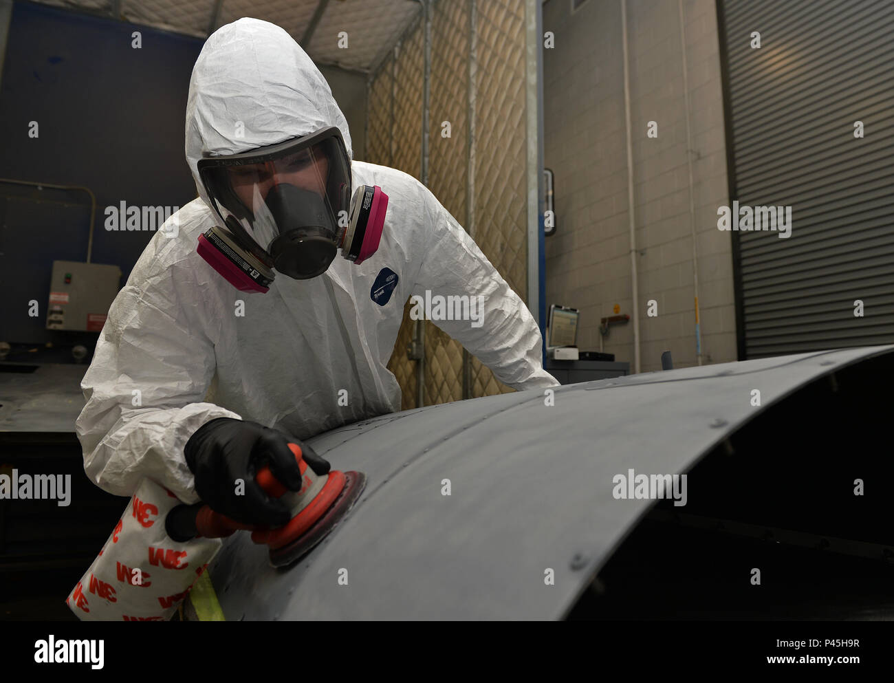 Airman Jay Adams, an aircraft structural maintenance journeyman with the 1st Special Operations Maintenance Squadron, sands an engine cowling at Hurlburt Field, Fla., June 29, 2016. The cowling has to be sanded to remove the old layer of paint in preparation for a new coat which will prevent corrosion. (U.S. Air Force photo by Senior Airman Andrea Posey) Stock Photo