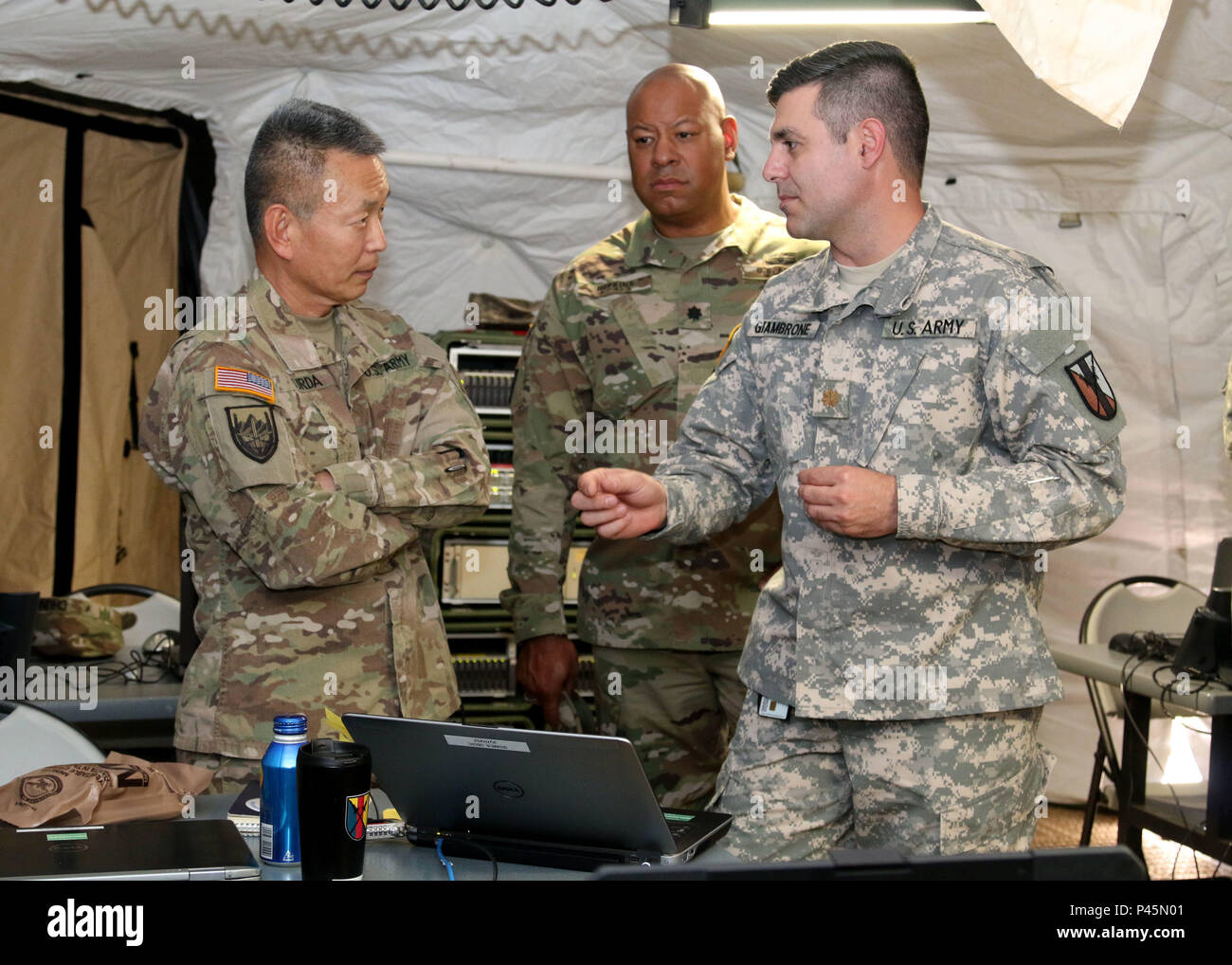 Brig. Gen. Stephen K. Curda (left), Commander, 9th Mission Support Command, Lt. Col. Frank E. Hopkins, deputy commander, 303rd Maneuver Enhancement Brigade (MEB), visits with Maj. Jamie R. Giambrone, communications officer in charge, 303rd MEB, during a visit to the S-6 shop at exercise Imua Dawn 2016, Sagamihara, Japan, June 18, 2016.  Imua Dawn 2016 focuses on maneuver support operations and enhancing cooperative capabilities in mobility, Humanitarian Assistance and Disaster Relief (HADR), Noncombatant Evacuation Operations (NEO), and sustainment support in the event of natural disasters and Stock Photo