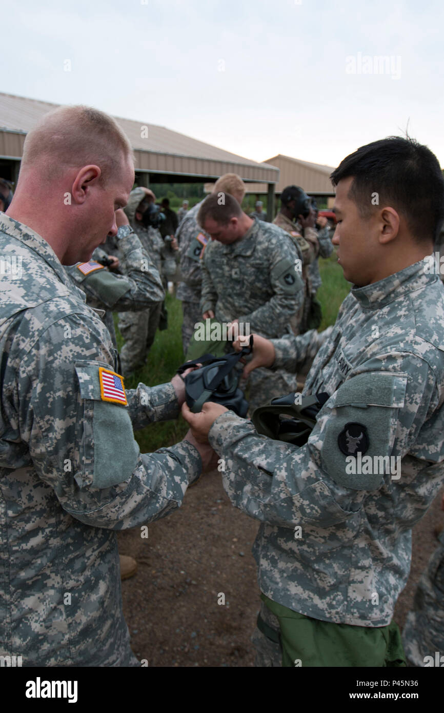 Soldiers with Headquarters Support Company, 834th Aviation Support Battalion, check the seal on their gas masks and prepare to go into the gas chamber for a nuclear, biological, and chemical training exercise at Camp Ripley, Minn., on June 17, 2016. CS gas is used for the training and is a tear gas. (Minnesota National Guard photo by Sgt. Sebastian Nemec, 34th Combat Aviation Brigade Public Affairs NCO) Stock Photo