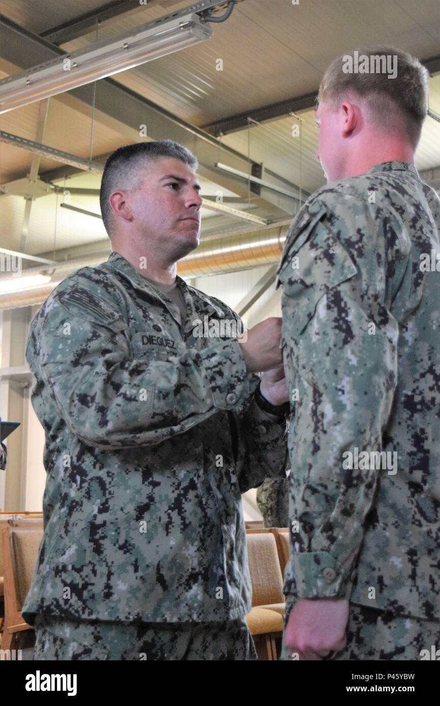 Constructionman Electrician Third Class Jacob Miller receives a