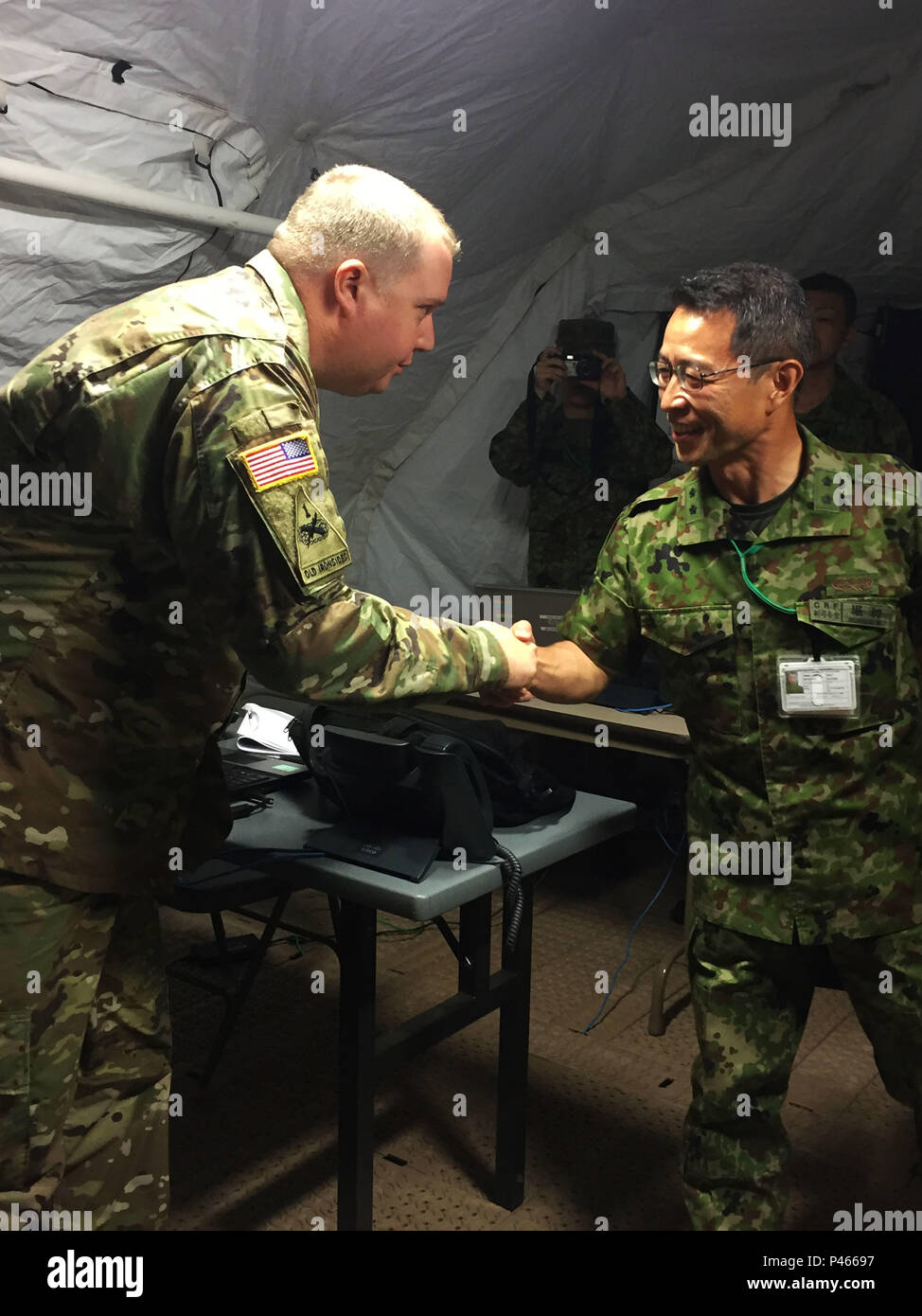 Maj. Gen. Mitsuhiko Horikiri (right), vice chief of staff (international), Japan Ground Self-Defense Force Central Readiness Force, shake hands with Cpt. Thomas N. Hacker, future plans and operations officer, 303rd Maneuver Enhancement Brigade, during a visit to Sagamihara Depot Mission Training Complex during exercise Imua Dawn 2016, Sagamihara, Japan, June 18, 2016. Imua Dawn 2016 provides opportunities for U.S. and the Japan Ground Self-Defense Force to come together and train for potential real world events. Humanitarian Assistance and Disaster Relief (HADR) and Noncombatant Evacuation Ope Stock Photo