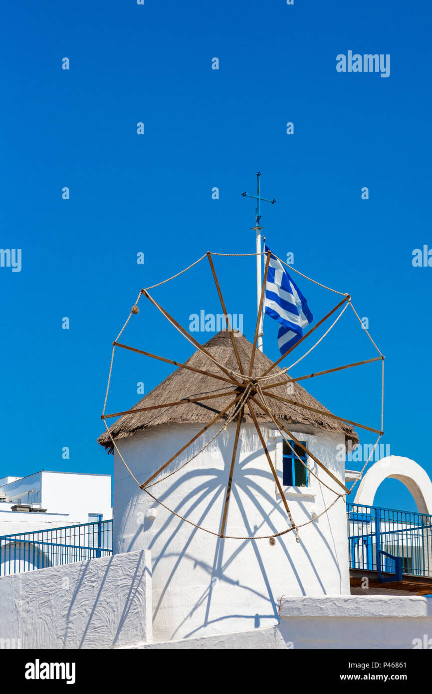 Traditional Greek styled windmill, with Greek flag against a blue sky, Ayia Napa, Cyprus Stock Photo