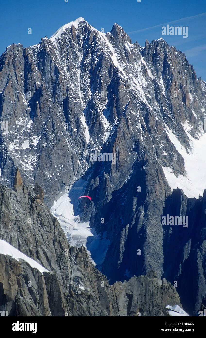 A parapente flying through the French Alps, with the gorgeous Aiguille Verte behind Stock Photo