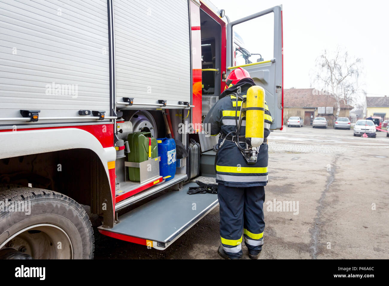 Firefighter is helping fellow to assembly his gear, keep balance and