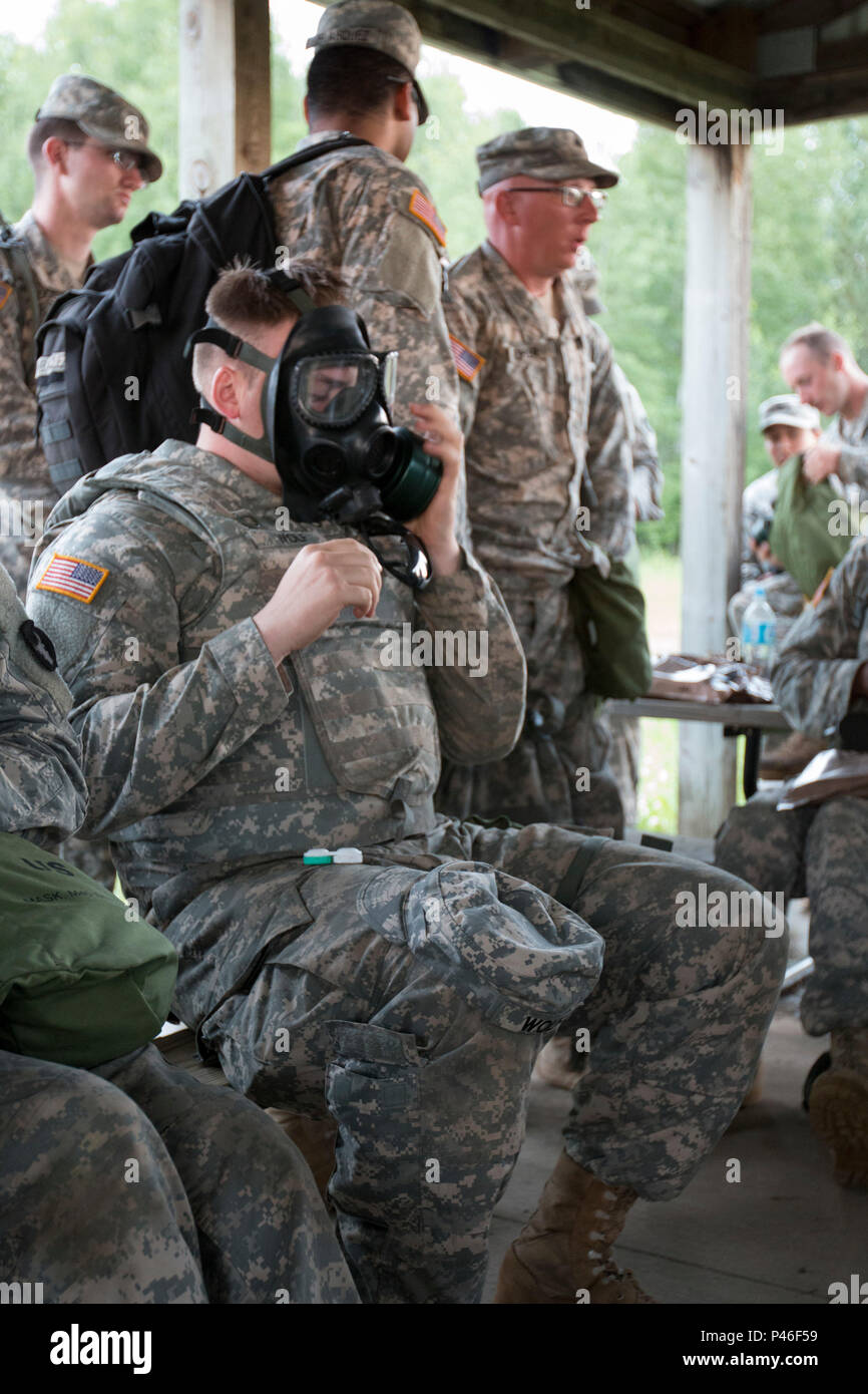 Soldiers with Headquarters Support Company, 834th Aviation Support Battalion, check the seal on their gas masks and prepare to go into the gas chamber for a nuclear, biological, and chemical training exercise at Camp Ripley, Minn., on June 17, 2016. CS gas is used for the training and is a tear gas. (Minnesota National Guard photo by Sgt. Sebastian Nemec, 34th Combat Aviation Brigade Public Affairs NCO) Stock Photo