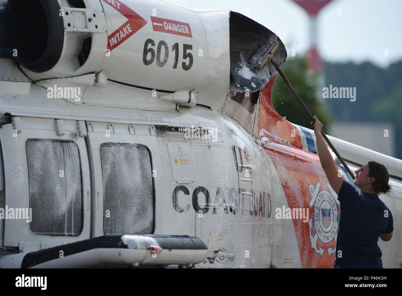 Over at Air Station Elizabeth City, Petty Officer 3rd Class Monique Pluard scrubs a MH-60 Jayhawk Monday, June 13, 2016. Constant maintanence and upkeep help air station crews remain mission ready at all times. U.S. Coast Guard illustration by Auxiliarist David Lau. Stock Photo