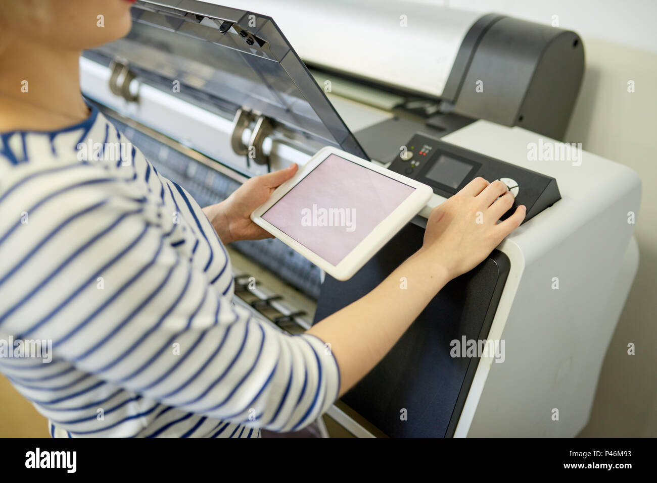 Faceless woman setting printer with tablet Stock Photo