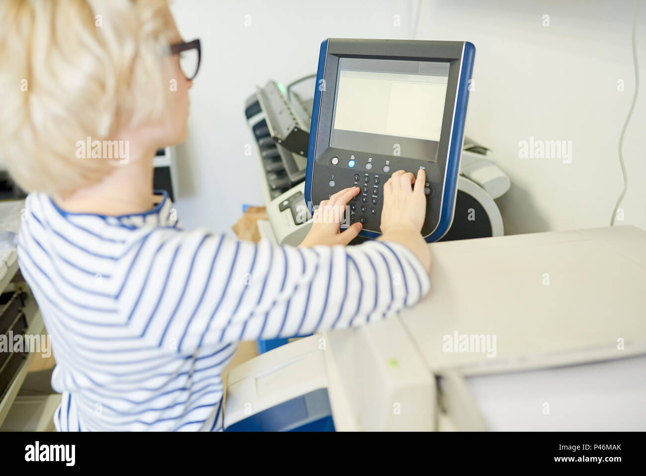 Young woman setting printer Stock Photo