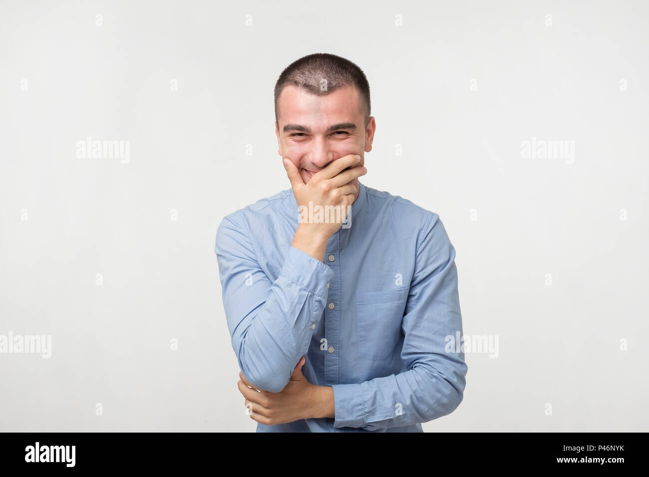 Young man trying not to laugh laughing covering mouth hi res stock photography and images Alamy
