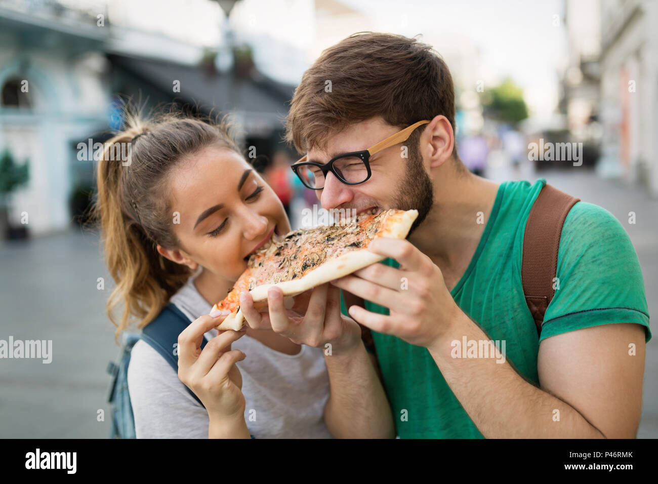 Happy group of people eating pizza outdoors Stock Photo