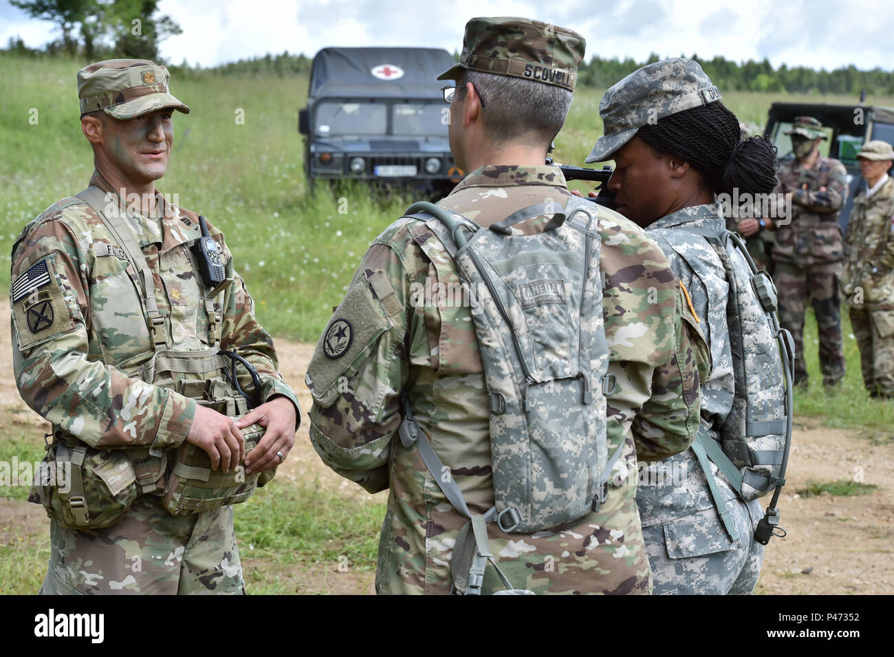 (From left to right) U.S. Army Maj. James Falcon, a surgeon with the 1st Brigade Combat Team, 82nd Airborne Division, answers questions to U.S. Army Staff Sgt. Mark Scovell and U.S. Army Sgt. Marline Duncon, both with 100th Mobile Public Affairs Detachment, during Exercise Swift Response 16, June 16, 2016 in Hohenfels, Germany. Exercise Swift Response is one of the premier military crisis response training events for multi-national airborne forces in the world. The exercise is designed to enhance the readiness of the combat core of the U.S. Global Response Force - currently the 82nd Airborne D Stock Photo