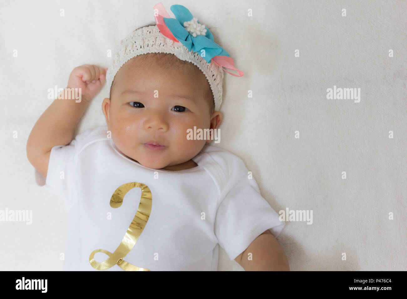 Close Up Two month old new born asian cute baby rests happily on
