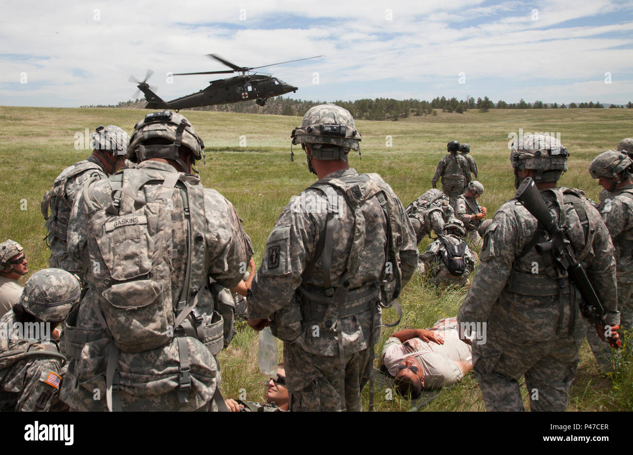 U.S. Army Soldiers of the 396th Medical Company (Ground Ambulance) and the 235th Military Police Company prepare wounded soldiers for a medical evacuation by a HH-60M Blackhawk helicopter during a mass casualty training lane for the Golden Coyote exercise, in Camp Guernsey, Wyo., June 18, 2016.  The Golden Coyote exercise is a three-phase, scenario-driven exercise conducted in the Black Hills of South Dakota and Wyoming, which enables commanders to focus on mission essential task requirements, warrior tasks and battle drills. (U.S. Army photo by Spc. Chenyang Liu/Not Released) Stock Photo