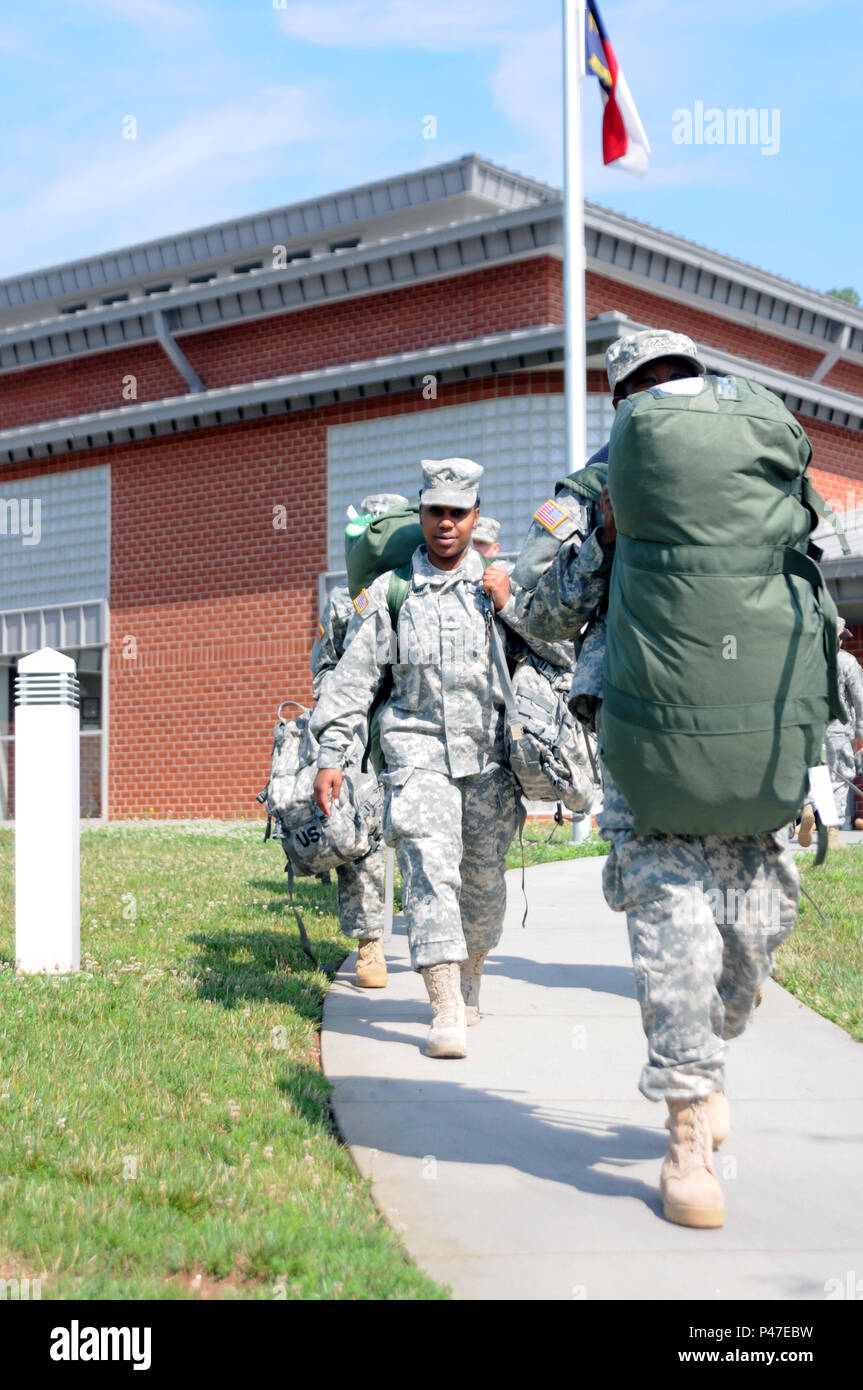 North Carolina Army National Guard Sgt. Janique Conner, a 630th Combat Sustainment Support Battalion human resource specialist, and other soldiers assigned to the 630th CSSB carry their luggage to a bus enroute to the National Training Center from Lenoir, North Carolina on June 4, 2016.  The NTC is a training facility designed to simulate real-life combat scenarios testing warriors’ readiness utilizing their military occupational specialty in a high-up-tempo environment.  (U.S. Army National Guard photo by Sgt. Leticia Samuels, 382nd Public Affairs Detachment/Released) Stock Photo