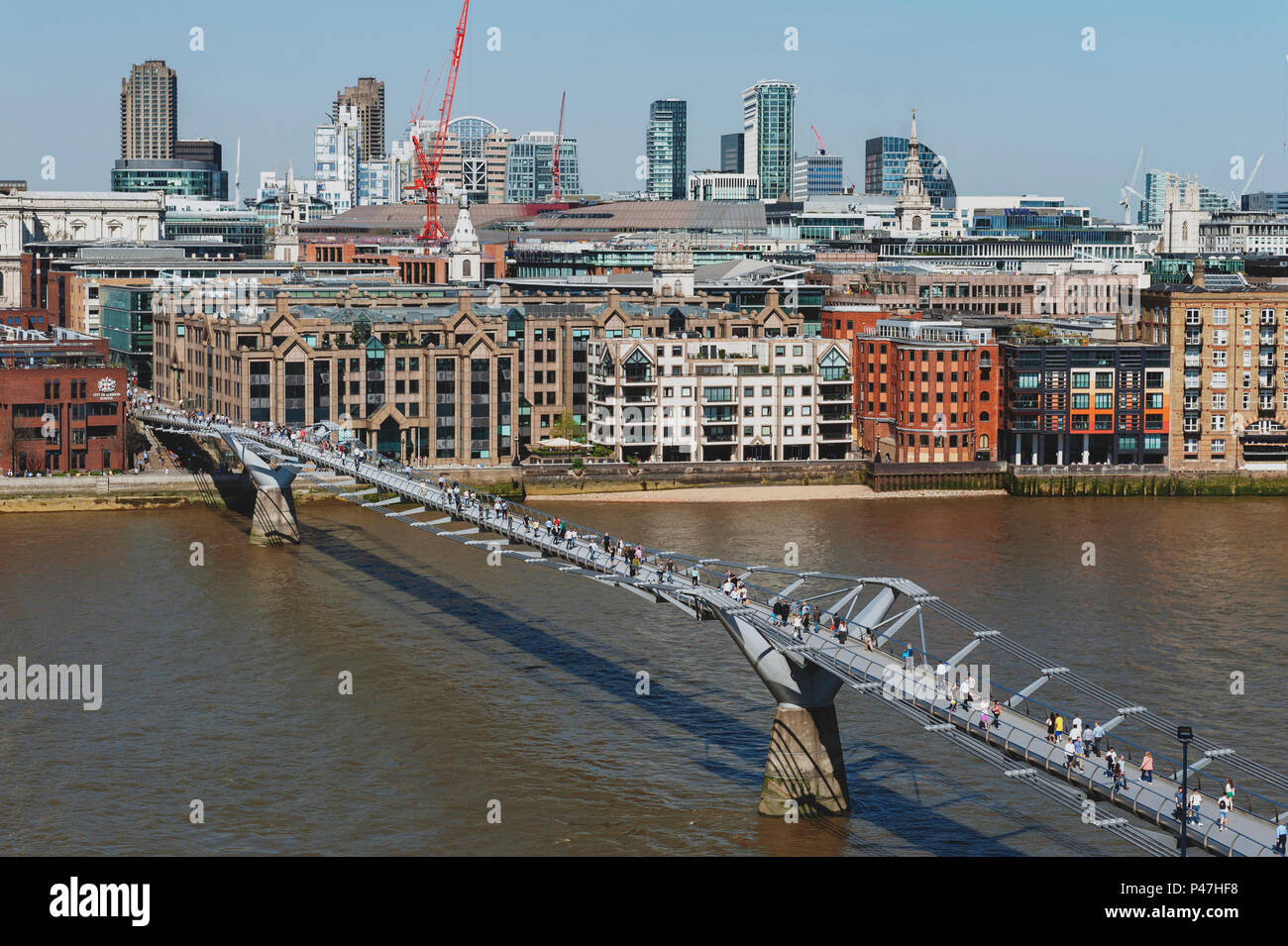 The London Millennium Bridge crossing the River Thames linking Bankside with the City of London, with skyline of London and St Paul Cathedral Stock Photo