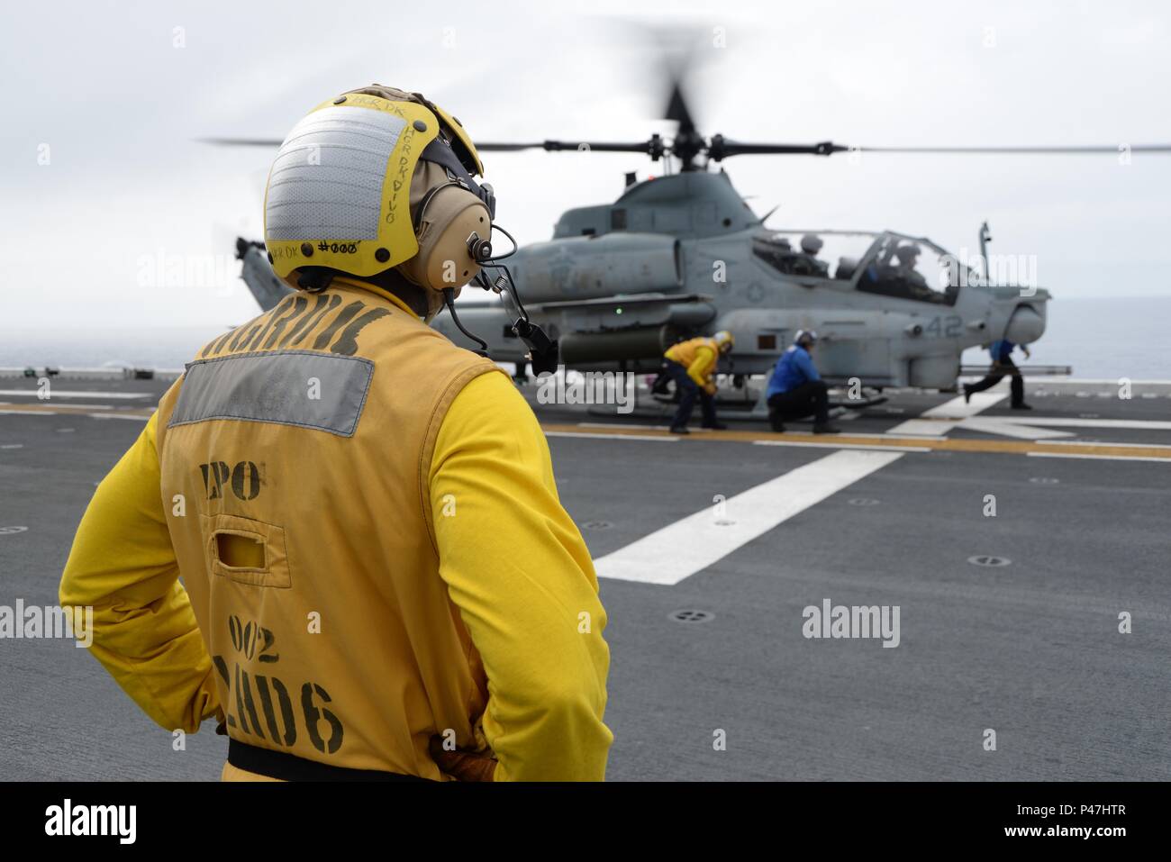 170612-N-YG104-004  PHILIPPINE SEA (June 12, 2017) Aviation Boatswains Mate 2nd Class Jessie Harris looks on as fellow Sailors chain down an AH-1 Super Cobra helicopter aboard the amphibious assault ship USS Bonhomme Richard (LHD 6). Bonhomme Richard is the flagship of the Bonhomme Richard Expeditionary Strike Group, which is on a routine deployment, operating in the Indo-Asia-Pacific region to serve as a forward-capability for any type of contingency. (U.S. Navy photo by Mass Communication Specialist 2nd Class Sarah Villegas/Released Stock Photo