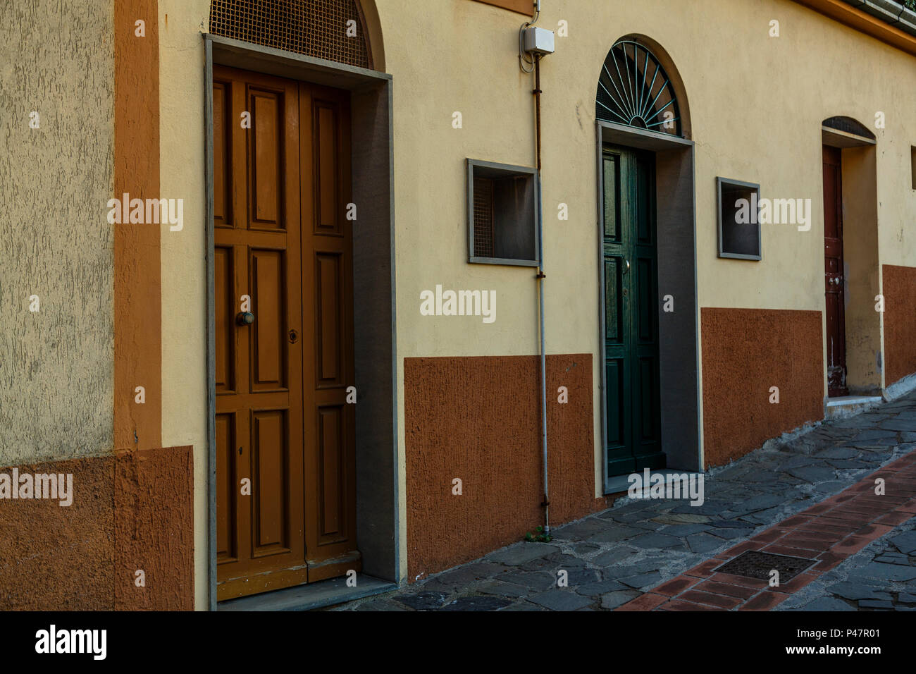 3 different old front doors line a quiet inclined passageway, Manarola, Cinque Terre Stock Photo