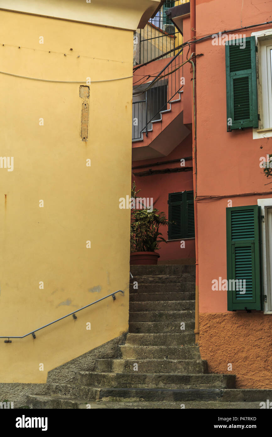 Two brightly colored homes bisected by the steep stone stairs of Manarola, Cinque Terre Stock Photo